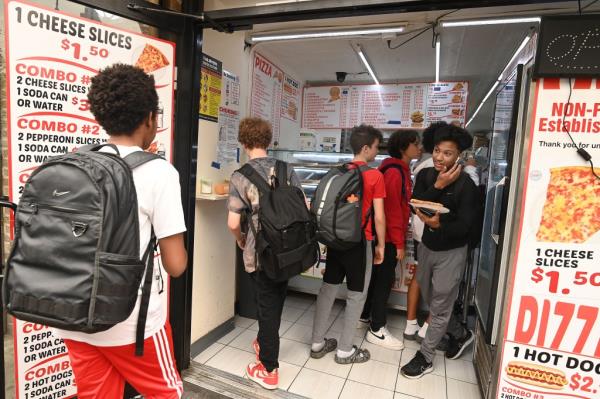 Kids crowding a now-$1.50 slice shop