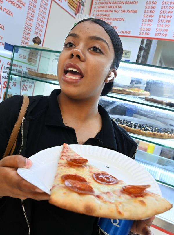 Naydeline Sanchez eating slice a pepperoni pizza
