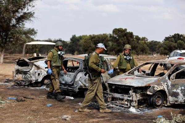 Israeli soldiers inspecting the damage at the scene of the festival attack.