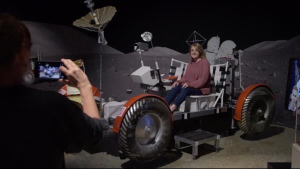 Lunar rover at the Intrepid museum. A woman sits on it and gets her picture taken. 
