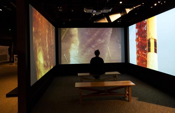 A visitor watches the Apollo 11 launch experience at the Intrepid Museum