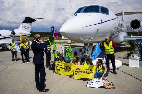 Enviro<em></em>nmental activists of Stay Grounded and Greenpeace demo<em></em>nstrate while handcuffing themselves to a plane during the European Business Aviation Co<em></em>nvention and Exhibition (EBACE), at the Geneve Aeroport in Geneva, Switzerland, on May 23, 2023.