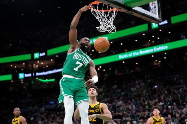 Boston Celtics guard Jaylen Brown (7) dunks the ball in front of Golden State Warriors forward Trayce Jackson-Davis  on Sunday.