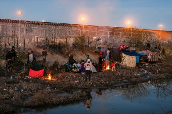 A group of migrants camp out along the border wall on the U.S. side of the Rio Grande after the U.S. Supreme Court let a Republican-backed Texas law known as SB 4 take effect, allowing state law enforcement authorities to arrest people suspected of crossing the U.S.-Mexico border illegally, in El Paso, Texas, U.S., as seen from Ciudad Juarez, Mexico March 19, 2024.  
