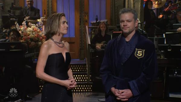 In an attempt to make her feel better, Damon points out that Wiig is the youngest member to join the club as well as the first female to join and Wiig points out that Emma Stone had been inducted before her and there are several women in the club. 