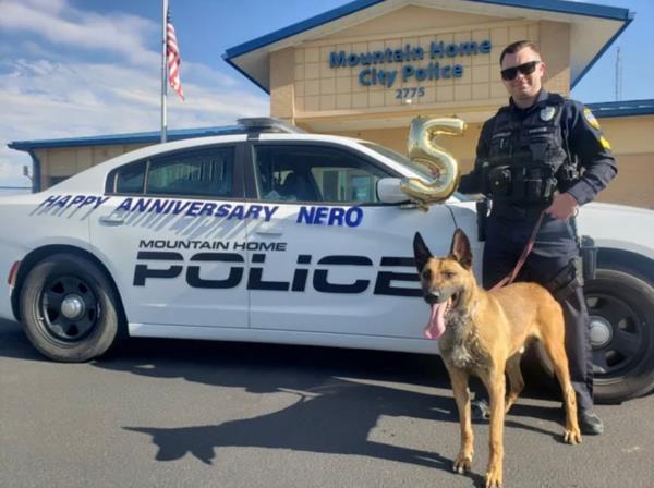 Nero is pictured with his handler in front of the Mountain Home Police Department on his fifth anniversary with the department.