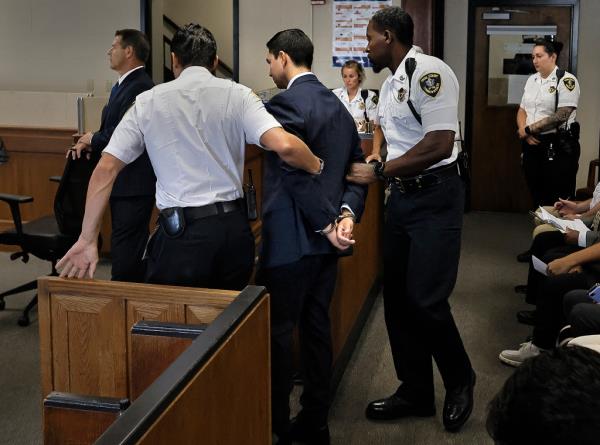 Matthew Nilo, in handcuffs, is escorted by court officers during an appearance at Suffolk Superior Court.