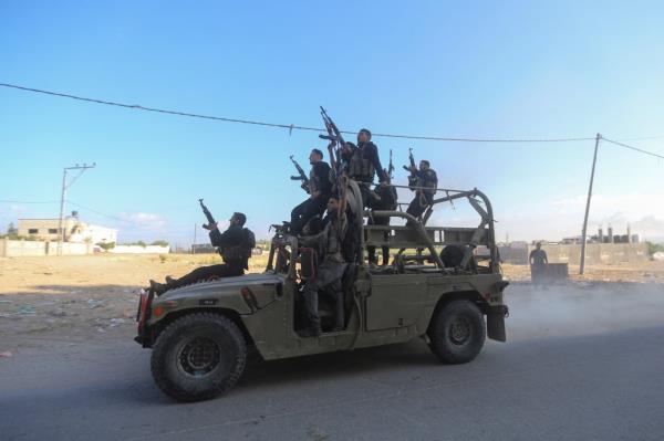 Palestinian militants ride an Israeli military vehicle that was seized by gunmen who infiltrated areas of southern Israel.