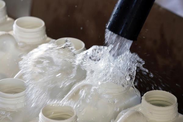 Phillips County fill one gallon jugs as other employees distribute water for people without water