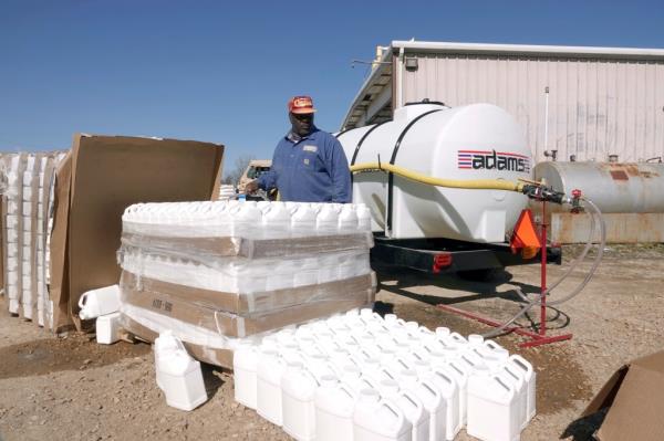 George Jackson fills up one gallon water jugs, while other Phillips County employees distribute water for people without water Tuesday, Jan. 30, 2024, in Helena, Arkansas.