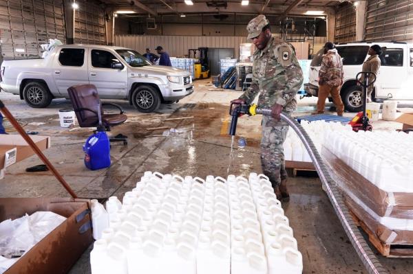 Jo<em></em>nathan McDowell, with the Natio<em></em>nal Guard, helps Phillips County employees distribute water