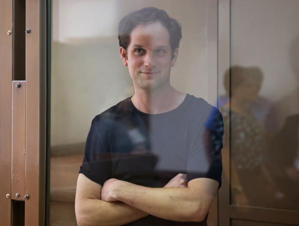 Wall Street Journal reporter Evan Gershkovich stands behind a glass wall of an enclosure for defendants before his court hearing in Moscow, Russia, on June 22, 2023.
