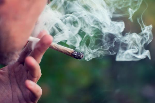 A man smoking a joint, medical marijuana use and cannabis legalization concept.