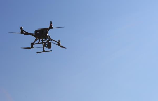 One of the dro<em></em>nes is seen in the sky above Rockaway Beach, mo<em></em>nitoring for shark activity.