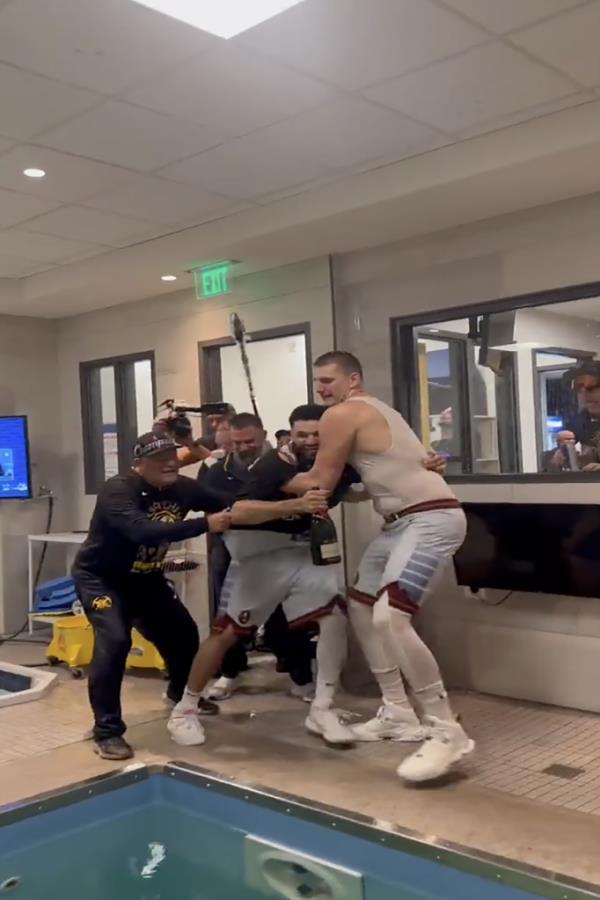 Nikola Jokic is seen trying to drag Jamal Murray into the arena pool after winning the Nuggets Game 5 win of the NBA Finals. 