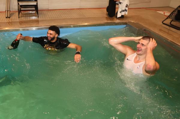 Jamal Murray and Nikola Jokic celebrate in the locker room pool during Game Five of the 2023 NBA Finals on June 12, 2023 at Ball Arena in Denver, Colorado. 