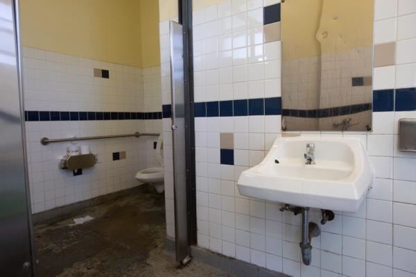 Public city park bathrooms with sink and toilet located in Forest Park, Forest Hills, NY on June 3, 2024.