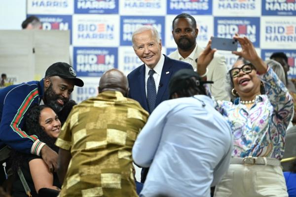 President Joe Biden takes photos with supporters during a campaign event at Cred Cafe in Detroit, Michigan on May 19, 2024. 