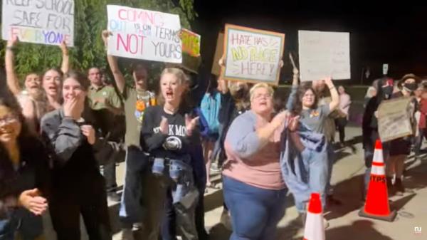 Protestors hold signs outside of Middletown school board meeting.