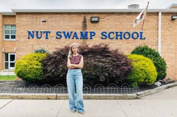 Laura Abt stands outside of an elementary school. 