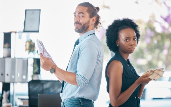 Money, gender bias and salary inequality in workplace between a team of equal professio<em></em>nal employee colleagues. Pay gap, corporate sexism and corrupt financial compensation or payment for woman staff.