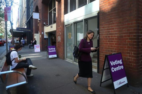 SYDNEY, AUSTRALIA - OCTOBER 09: Pedestrians move past a polling centre in the central business district on October 09, 2023 in Sydney, Australia. A referendum for Australians to decide on an indigenous voice to parliament will be held on October 14, 2023 and compels all Australians to vote by law. Early voting began on Oct. 2, with voting getting underway in all states. (Photo by Lisa Maree Williams/Getty Images)