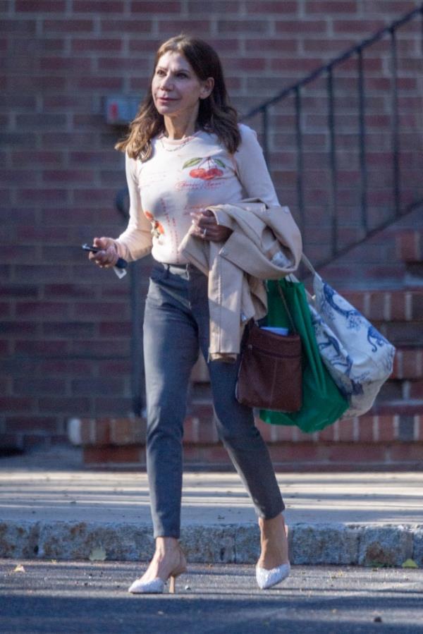 Theresa Nist, wearing skinny jeans and a cherry patterned sweater, stepping out in New Jersey with her wedding band visible after announcing her breakup from Gerry Turner.