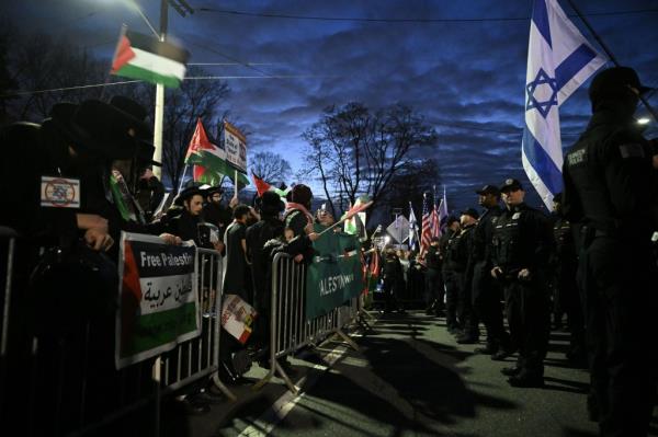 Pro-Palestinian and Pro-Israeli demo<em></em>nstrators protesting against a ZAKA meeting in New Jersey, with police securing the area and Avraham Fried amo<em></em>ngst the crowd