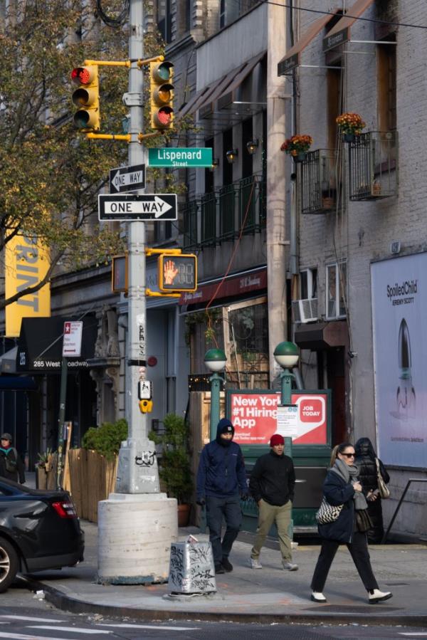 A photo of people walking by the upside down light.