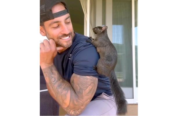 Peanut the Squirrel climbing on owner Mark Longo's shoulder.