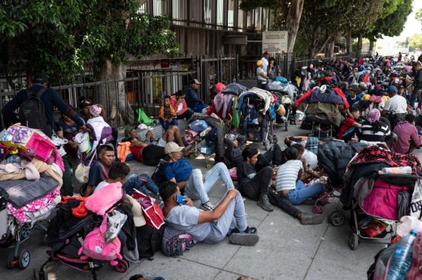 Migrants rest on a sidewalk in Mexico City while traveling in a caravan to the US.