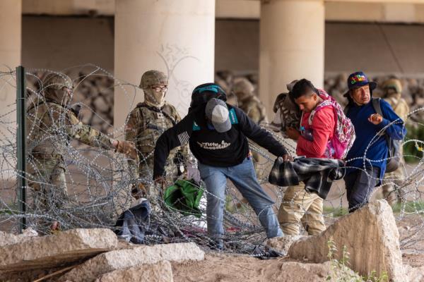 Texas Natio<em></em>nal Guard pushed back a large group of almost 60 migrants who crossed the border illegally and breached the co<em></em>ncertina wire barriers set up along the US side of the Rio Grande river. The migrants had made it to the actual border wall but were forced back across the razor wire defenses by soldiers telling them to enter the US at a legal point of entry to claim asylum, pointing to the Zaragoza bridge above them.
