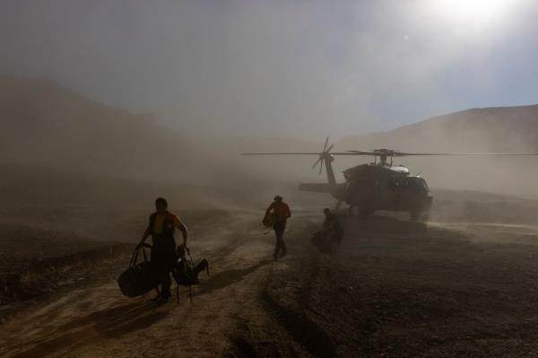 Rescuers exit a helicopter to arrive at a ba<em></em>se camp to take part in a rescue operation to reach U.S. caver Mark Dickey.
