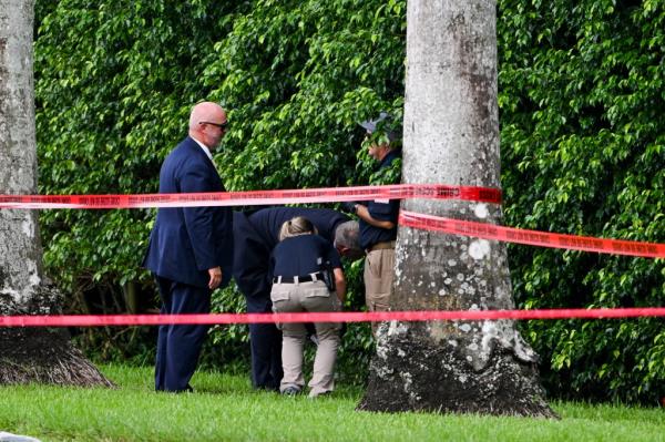 Law enforcement officials work near the crime scene outside the Trump Internatio<em></em>nal Golf Club in West Palm Beach, Florida.