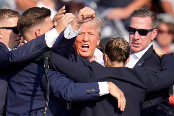 Former President Do<em></em>nald Trump exiting the stage with help from Secret Service agents at a 2024 campaign event in Butler, PA