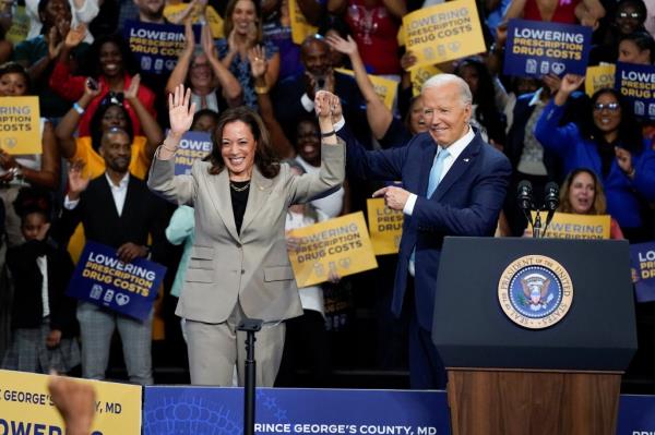 U.S. President Joe Biden raising the hand of Vice President Kamala Harris at a Medicare drug price negotiation event in Prince George's County, Maryland, August 15, 2024