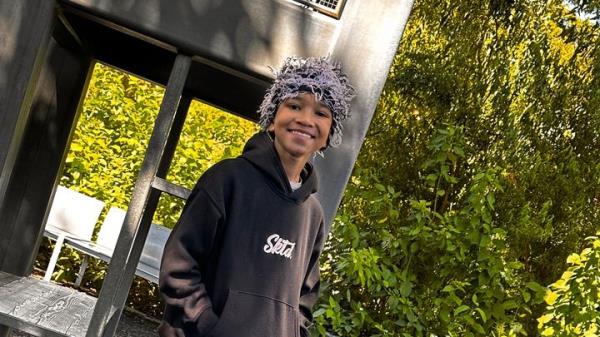 11 year-old Cayden Thompson wearing a fuzzy hat and a sweatshirt.