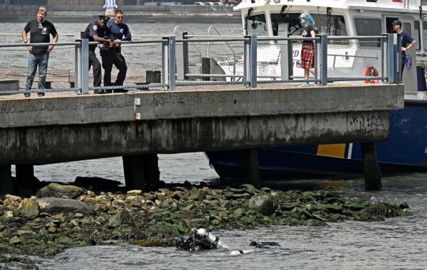 8/19/24  Several human remains were found underneath the rocks inside Empire Fulton Ferry State Park.  It is not known wher<em></em>e the body parts came from.  Here, NYPD officers pull bo<em></em>nes out from under the rocks. (pictured) Near Dock Street and Water Street, Brooklyn, NY.  