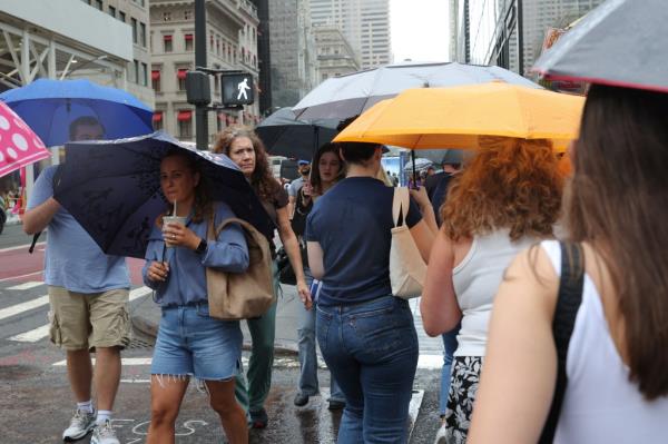 People using umbrellas in heavy wind and rain during a storm in New York City, August 9, 2024