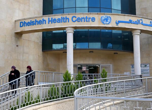 Palestinian refugees stand outside the entrance to the UN Relief and Works Agency for Palestinian refugees (UNWRA) Health Clinic in the Dheisheh Refugee Camp near Bethlehem, West Bank, on Tuesday, January 30, 2024.