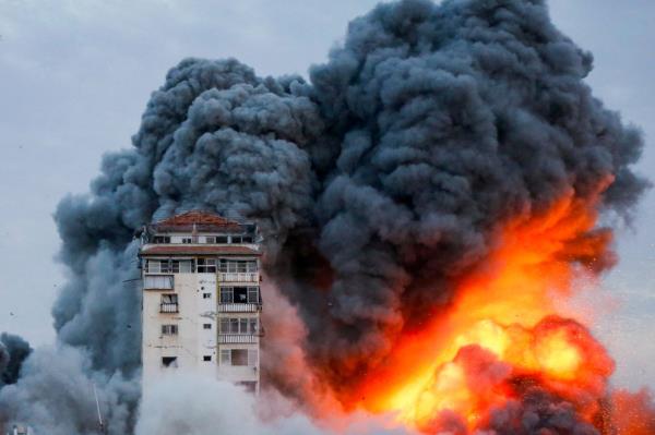 Smoke and flames billow after Israeli forces struck a high-rise tower in Gaza City, October 7, 2023. 