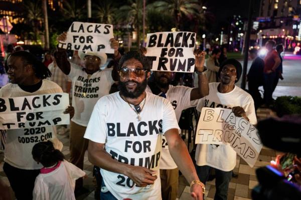 Blacks for Trump hold signs outside the Palm Beach County Co<em></em>nvention Center wher<em></em>e former President Do<em></em>nald Trump is havin<em></em>g his election party on November 5, 2024, in West Palm Beach, Florida.