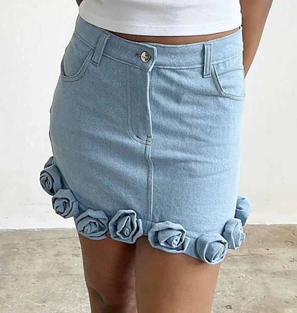 A woman wearing a denim Ira Roses Skirt from brand TACH, priced at $205