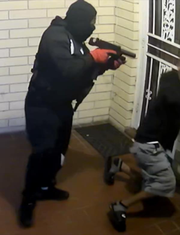 The suspects are pictured breaking into one of the houses.