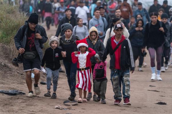 Hundreds of migrants follow border agents after crossing illegally into Eagle Pass, Texas.