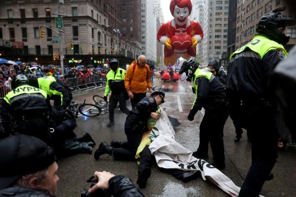 Police officers detain protesters during the 98th Macy's Thanksgiving Day Parade in New York City, U.S., November 28, 2024. 