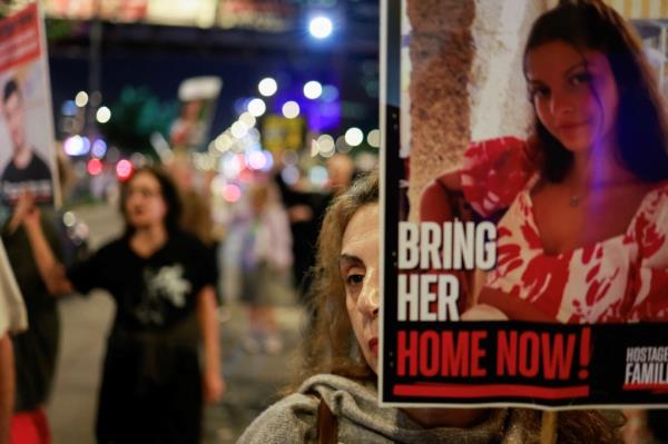 A woman holds a sign, as demo<em></em>nstrators protest against the Israeli government's management of the o<em></em>ngoing co<em></em>nflict in Gaza between Israel and Hamas and to show support for the hostages who were kidnapped during the deadly October 7 2023 attack, following the Internatio<em></em>nal Criminal Court's decision to issue arrest warrants for Israeli Prime Minister Benjamin Netanyahu and his former defense minister Yoav Gallant, in Tel Aviv, Israel November 21, 2024. 