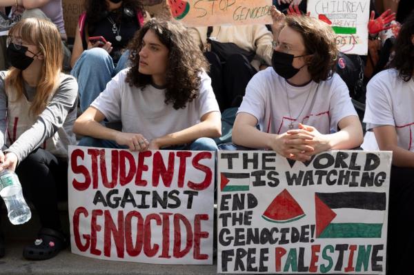 Students hold signs that read 'STUDENTS AGAINST GENOCIDE' 'THE WORLD IS WATCHING END THE GENOCIDE! FREE PALESTINE' at a protest in New York City on May 31