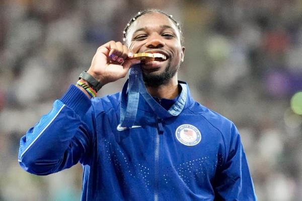Noah Lyles poses with his gold medal from the 100-meter sprint in the 2024 Paris Olympics.
