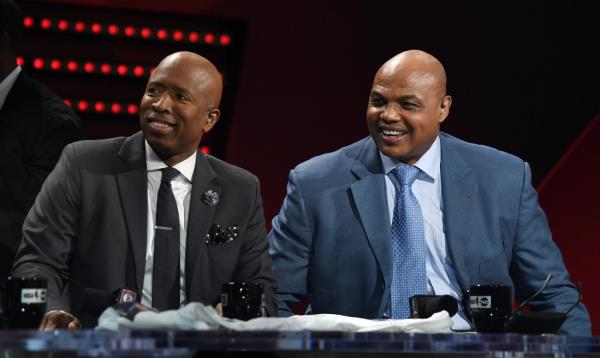 NBA analysts Kenny Smith (L) and Charles Barkley laugh during a live telecast of 